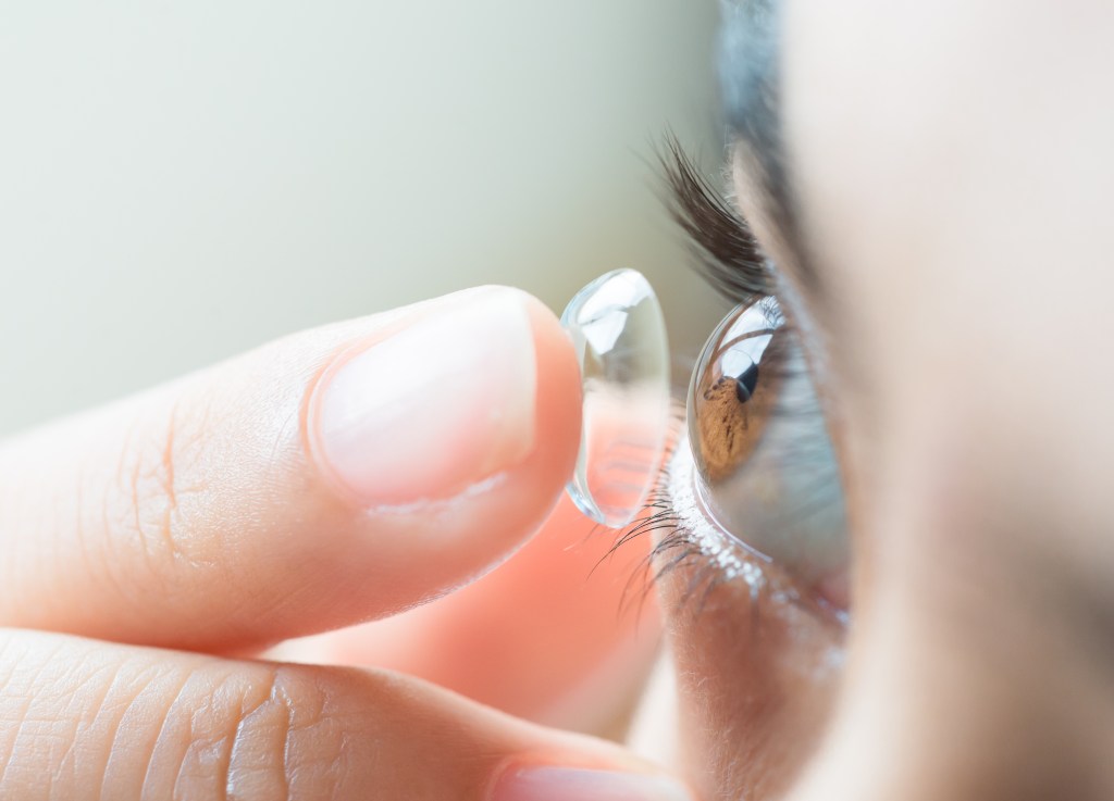 , die Kontaktlinsen auf das Auge setztVision
