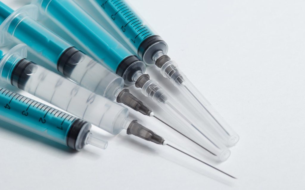 Various plastic syringes on a white background